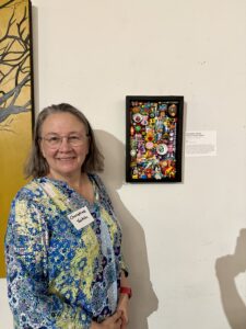 Christine Veitch stands next to her piece, Hearts & Flowers